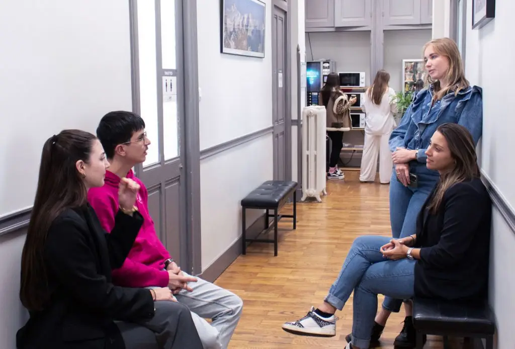 Couloir à l'école EAP de Grenoble avec des étudiants discutant.